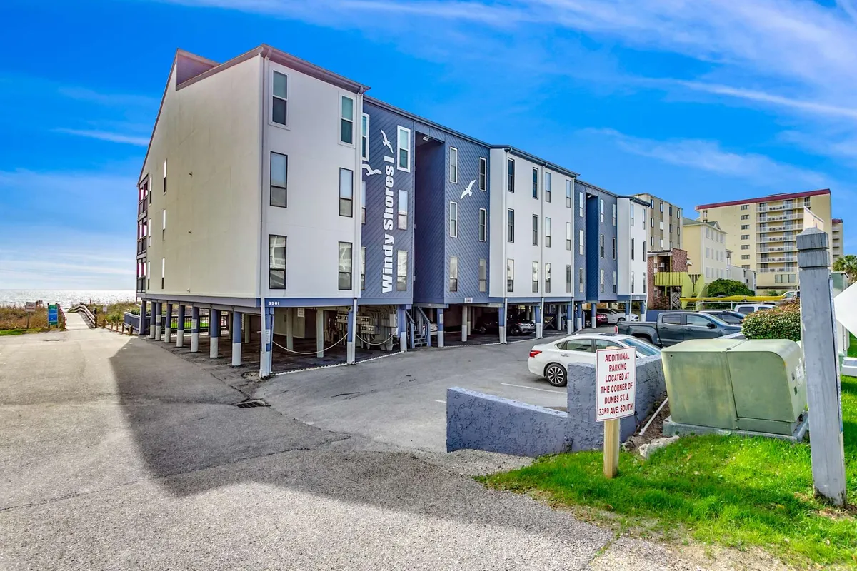 A welcoming view of the property’s modern exterior, complete with visible parking area and clear signage. The overall mood is casual, with easy access for guests, reinforcing convenience and security.