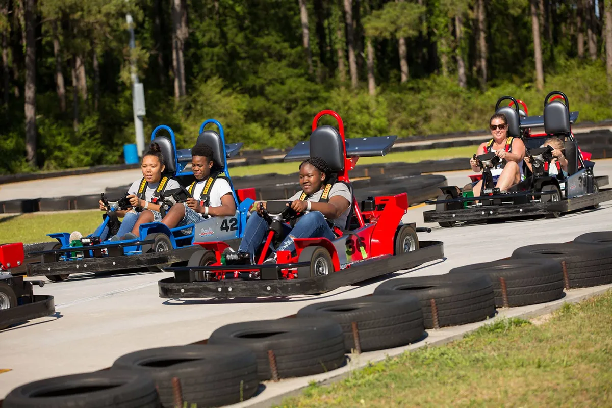 An exterior shot featuring a lively go-kart racetrack with participants in motion, capturing the excitement and energy of family-friendly racing. The image focuses on the thrill of the activity, with families and friends visibly engaged in the fun.